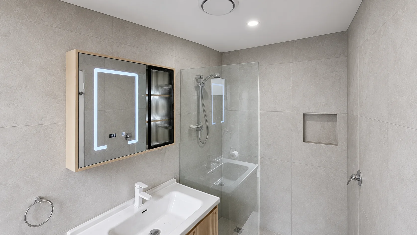 Renovated bathroom with a backlit LED mirror cabinet, walk-in shower and vanity, wired and lit by KPJ Electrical